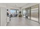 Bright living room featuring light wood floors, desk area, and glass sliding doors to outside patio at 964 Norwood Heights Ln, Las Vegas, NV 89138