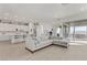Bright living room with a modern sofa, open floor plan, and sliding glass doors at 964 Norwood Heights Ln, Las Vegas, NV 89138