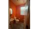 The bathroom has bright orange walls and a vanity sink, giving the room a warm ambiance at 1001 Pebble Lake St, Henderson, NV 89011