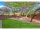 Beautiful backyard featuring trees, artificial grass, a brick-paved area, and outdoor seating at 10223 Aragon Crown Rd, Las Vegas, NV 89135