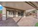 A spacious backyard with a covered patio, ceiling fan, and sliding glass doors leading into the house at 10223 Aragon Crown Rd, Las Vegas, NV 89135