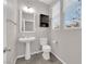 Cozy powder room featuring a pedestal sink, dark vanity cabinet, and bright natural light at 10223 Aragon Crown Rd, Las Vegas, NV 89135