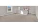 Bright bonus room featuring plush carpeting, natural light, and staircase access at 10223 Aragon Crown Rd, Las Vegas, NV 89135