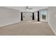 Large bonus room featuring plush carpets, a ceiling fan, and large windows with black curtains at 10223 Aragon Crown Rd, Las Vegas, NV 89135
