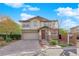 Charming two-story home with stone accents, a well-manicured lawn, and a brick driveway at 10223 Aragon Crown Rd, Las Vegas, NV 89135