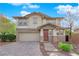 Charming two-story home with stone accents, a well-manicured lawn, and a brick driveway at 10223 Aragon Crown Rd, Las Vegas, NV 89135