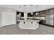 Open concept kitchen with gray counters, dark cabinetry, island, and stainless appliances at 10223 Aragon Crown Rd, Las Vegas, NV 89135