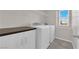 Laundry room with modern washer and dryer, ample storage, and tile flooring at 10223 Aragon Crown Rd, Las Vegas, NV 89135