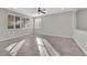 Bright living room featuring large windows, neutral paint, ceiling fan, and modern tile flooring at 10223 Aragon Crown Rd, Las Vegas, NV 89135