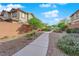 Gravel-covered side yard pathway, framed by mature shrubs and a brick privacy fence at 10223 Aragon Crown Rd, Las Vegas, NV 89135