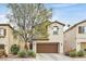 Charming two-story home with desert landscaping and a brown two car garage door at 10574 Siesta Key St, Las Vegas, NV 89141
