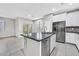 Kitchen island featuring stone countertops, stainless steel appliances, white cabinets, and sliding door to the yard at 10574 Siesta Key St, Las Vegas, NV 89141