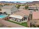 Drone shot of a backyard featuring a pool, grassy area, and covered patio at 1140 Highbury Grove St, Henderson, NV 89002