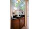 Wet bar with dark wood cabinets and mirrored wall next to entryway at 125 E Harmon Ave # 3406 & 3408, Las Vegas, NV 89109