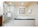 Bright bathroom featuring a glass enclosed shower and a soaking tub with black countertop at 125 E Harmon Ave # 3406 & 3408, Las Vegas, NV 89109