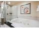 Bright bathroom featuring a glass enclosed shower and soaking tub with neutral tiling and art at 125 E Harmon Ave # 3406 & 3408, Las Vegas, NV 89109
