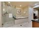 Modern bathroom featuring a glass-enclosed shower, a soaking tub, and tile flooring at 125 E Harmon Ave # 3406 & 3408, Las Vegas, NV 89109