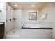 Bright bathroom featuring a glass enclosed shower and soaking tub with neutral tiling and art at 125 E Harmon Ave # 3406 & 3408, Las Vegas, NV 89109