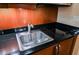 Kitchenette featuring dark wood cabinets, a stainless steel sink and cooktop on the counter at 125 E Harmon Ave # 3406 & 3408, Las Vegas, NV 89109