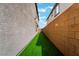 A modern backyard featuring artificial turf, brick walls, and views of the surrounding neighborhood at 1364 Cerulean Ave, Henderson, NV 89002
