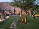 Beautiful backyard featuring stone pathways, artificial grass, a fire pit, mature trees and an outdoor living area at 176 Brighton Hills Ave, Henderson, NV 89002