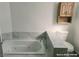 Bathroom featuring a tiled corner bathtub and nearby toilet under a mounted storage cabinet at 1828 Casa Vista Dr, Las Vegas, NV 89146