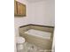 Bright bathroom with a jacuzzi tub featuring attractive stone-look tile work and a toilet at 1828 Casa Vista Dr, Las Vegas, NV 89146
