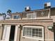 An exterior view shows a two-story home with a balcony and stucco siding under a clear blue sky at 1828 Casa Vista Dr, Las Vegas, NV 89146