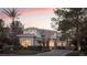Elegant two-story home showcasing manicured landscaping, mature trees, and a circular driveway at 2041 Troon Dr, Henderson, NV 89074