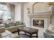 Cozy living room featuring a stone fireplace, comfortable seating, and natural light from a nearby window at 2041 Troon Dr, Henderson, NV 89074