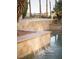Water cascades into the swimming pool, complete with ledgestone and landscaping at 2041 Troon Dr, Henderson, NV 89074
