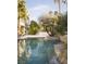 Enjoy this backyard swimming pool and water feature surrounded by lush landscaping at 2041 Troon Dr, Henderson, NV 89074