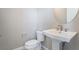 Powder room featuring pedestal sink, toilet, and modern fixtures at 2509 Silent View Ave, Henderson, NV 89044