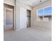 Bright bedroom featuring a double-door closet and open doorway, with a view of exterior buildings at 2509 Silent View Ave, Henderson, NV 89044