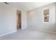 Bright, carpeted room with open bathroom and natural light from a single window at 2509 Silent View Ave, Henderson, NV 89044