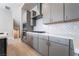 This contemporary kitchen features gray cabinetry, a white backsplash, and stainless steel appliances at 2509 Silent View Ave, Henderson, NV 89044