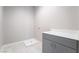 Well-organized laundry room with tiled floors, grey cabinets, a white countertop, and a utility sink at 2509 Silent View Ave, Henderson, NV 89044