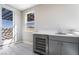 Bright area with a wet bar, featuring stainless steel beverage cooler and outdoor views at 2509 Silent View Ave, Henderson, NV 89044
