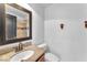Cozy bathroom features granite countertops, wood vanity, an under-mount sink, and framed mirror at 2566 Antique Blossom Ave, Henderson, NV 89052