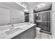 Double vanity in bathroom with tile floors, granite countertop, and grey cabinets at 2566 Antique Blossom Ave, Henderson, NV 89052