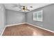 A spacious bedroom boasts wood-look floors, a ceiling fan, and a bright window at 2566 Antique Blossom Ave, Henderson, NV 89052