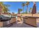 An outdoor kitchen with a grill overlooks the pool and lush landscaping at 2566 Antique Blossom Ave, Henderson, NV 89052