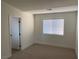 Cozy bedroom featuring carpet floors, a window with blinds, and a door to the hallway at 2621 Adelante Ave # 102, Las Vegas, NV 89106