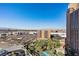 Expansive aerial view showcases a vibrant city, mountains, and a palm-lined pool area below at 2700 Las Vegas Blvd # 1202, Las Vegas, NV 89109