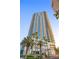 Towering modern high-rise building, featuring blue-tinted windows and palm trees against a beautiful sunny sky at 2700 Las Vegas Blvd # 1202, Las Vegas, NV 89109
