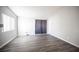 Bright bedroom with sliding glass door access, neutral gray walls, and gray wood flooring at 2725 S Nellis Blvd # 2045, Las Vegas, NV 89121