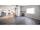 Spacious living room adjacent to an open kitchen features a fireplace and grey wood floors at 2725 S Nellis Blvd # 2045, Las Vegas, NV 89121