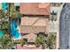 Aerial view of a tile roofed home with an inviting kidney shaped swimming pool, surrounded by mature landscaping and lounge chairs at 28 Birkdale Dr, Henderson, NV 89074