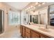 Bright primary bathroom features a dual sink vanity, tile flooring, and a glass enclosed shower at 28 Birkdale Dr, Henderson, NV 89074