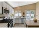 Bright kitchen features stainless steel appliances, white cabinets, and a sliding glass door to the backyard at 280 Pear Meadow St, Henderson, NV 89012